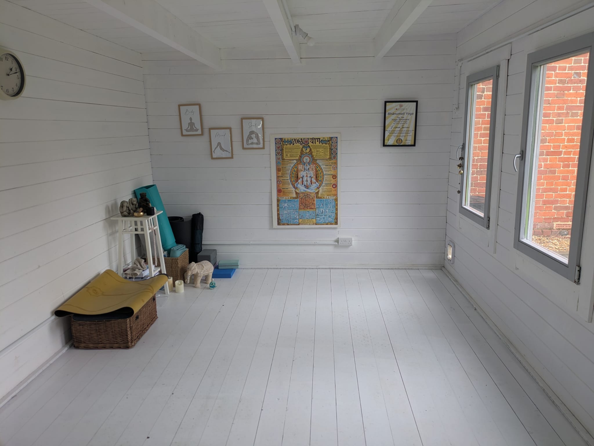 A calm white indoor space prepared for one-to-one yoga sessions.